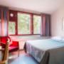 Yhden hengen hostellihuone leveällä vuoteella